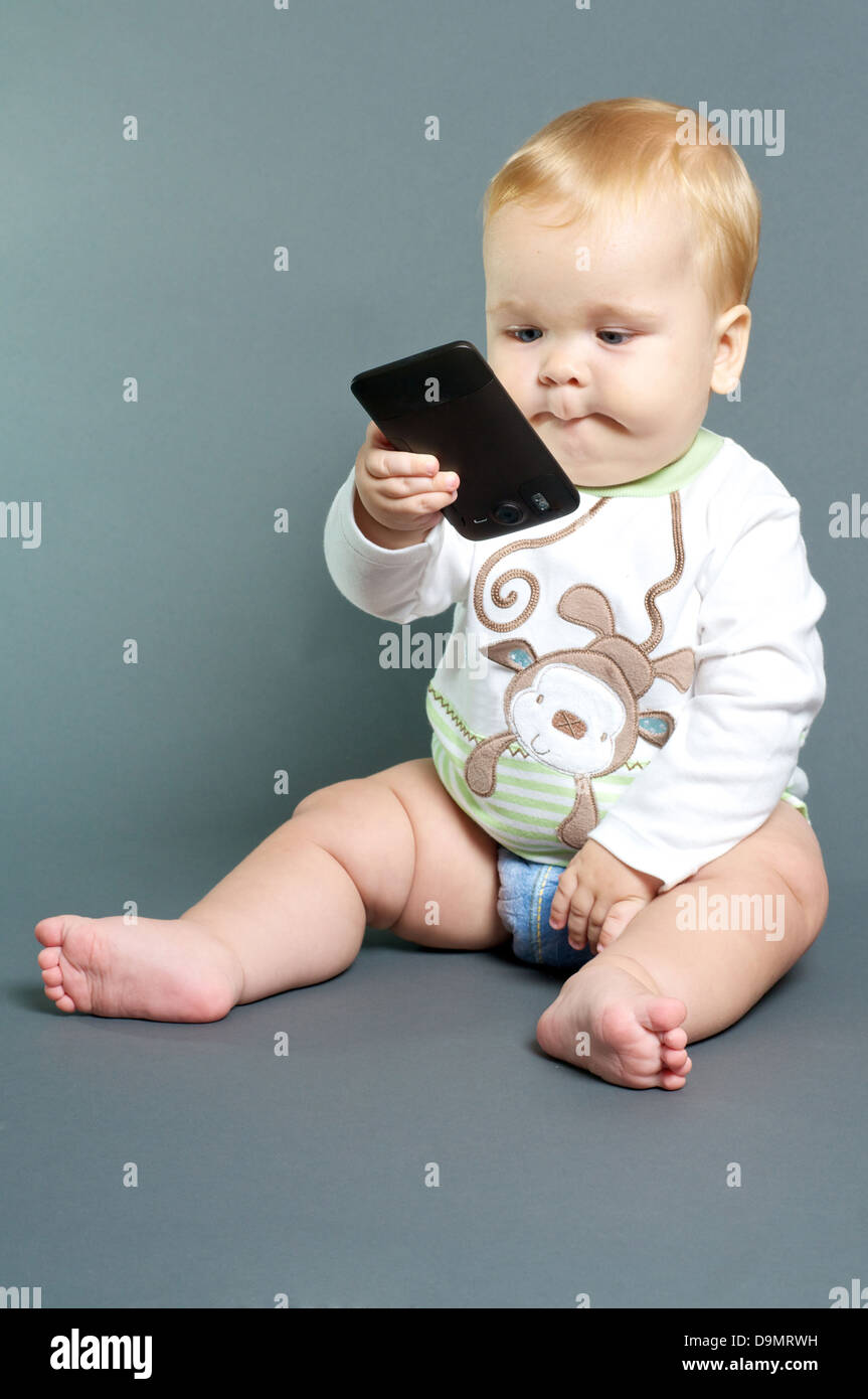 Blond bébé texting with smart phone Banque D'Images
