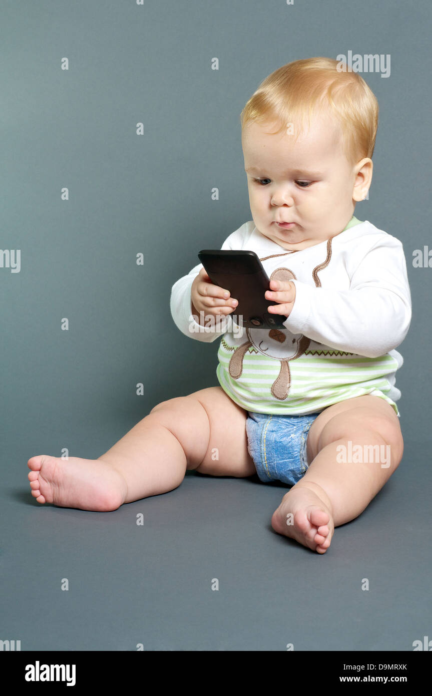 Blond bébé texting with smart phone Banque D'Images