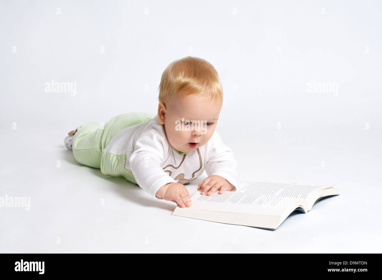 Smart blond bébé lire un livre Banque D'Images