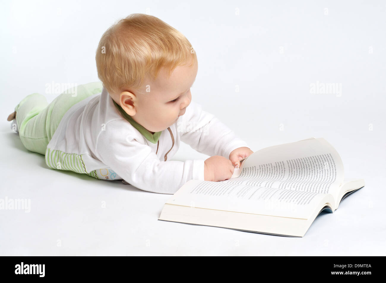 Smart blond bébé lire un livre Banque D'Images