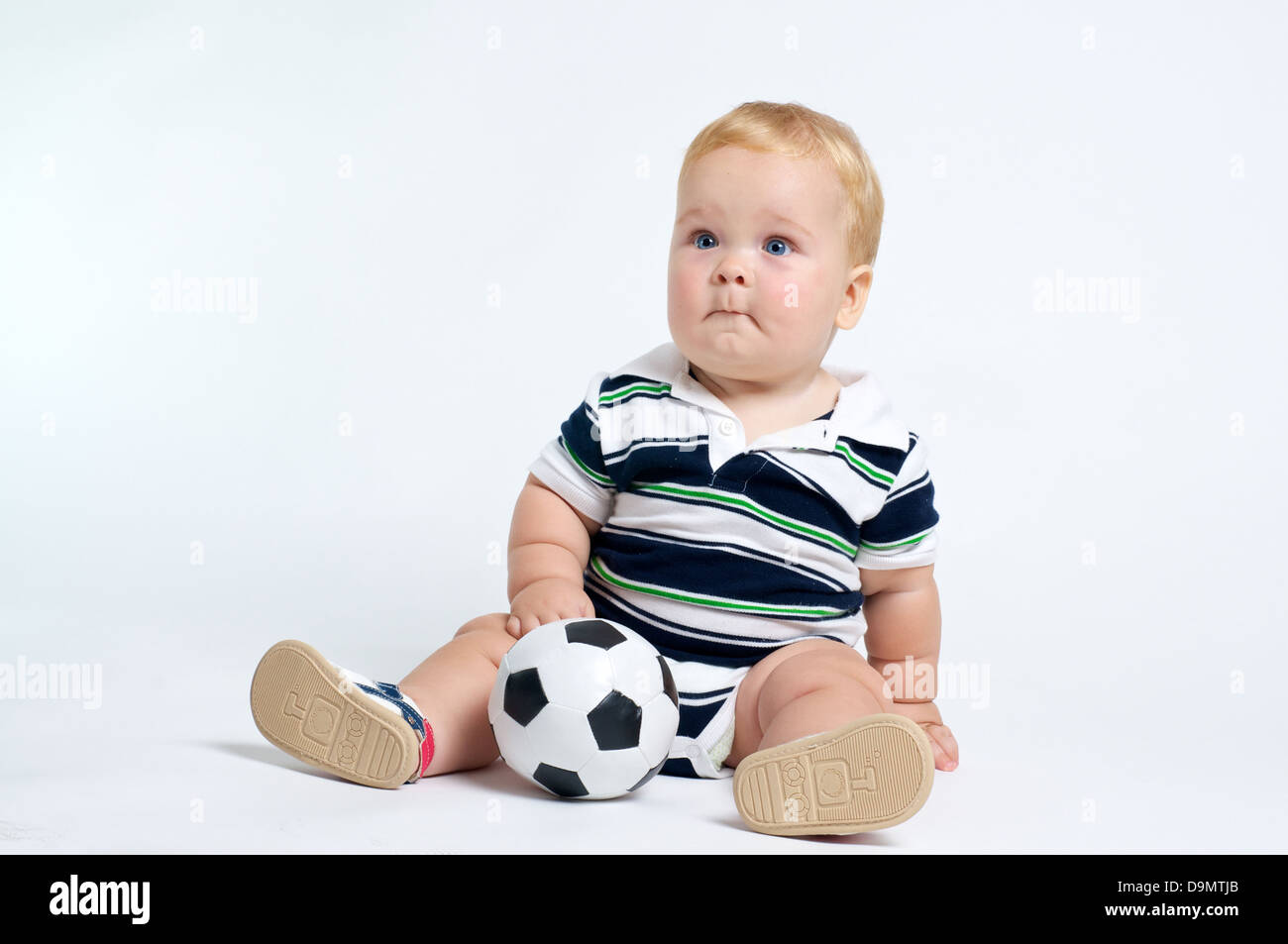 Cute blonde aux yeux bleus de bébé jouer avec ballon de soccer Banque D'Images