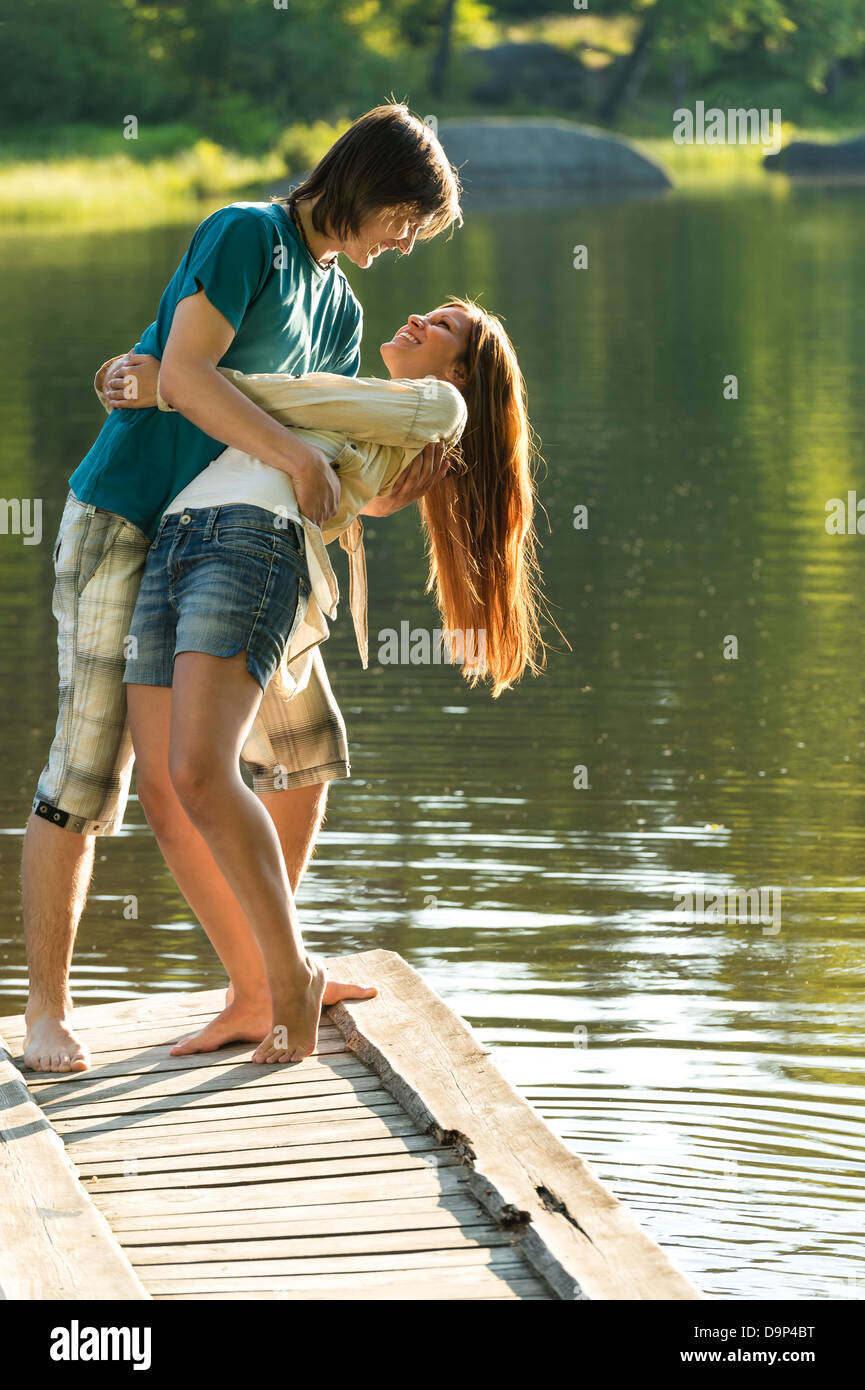 Smiling playful couple having fun on pier lake Banque D'Images