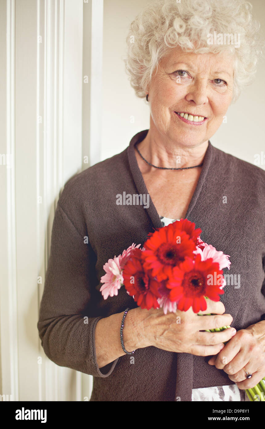 Happy senior woman holding a bouquet de fleurs fraîches Banque D'Images
