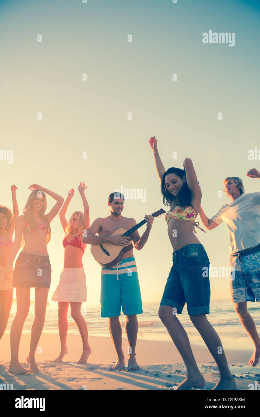 Les amis de la danse et s'amusant sur la plage Banque D'Images