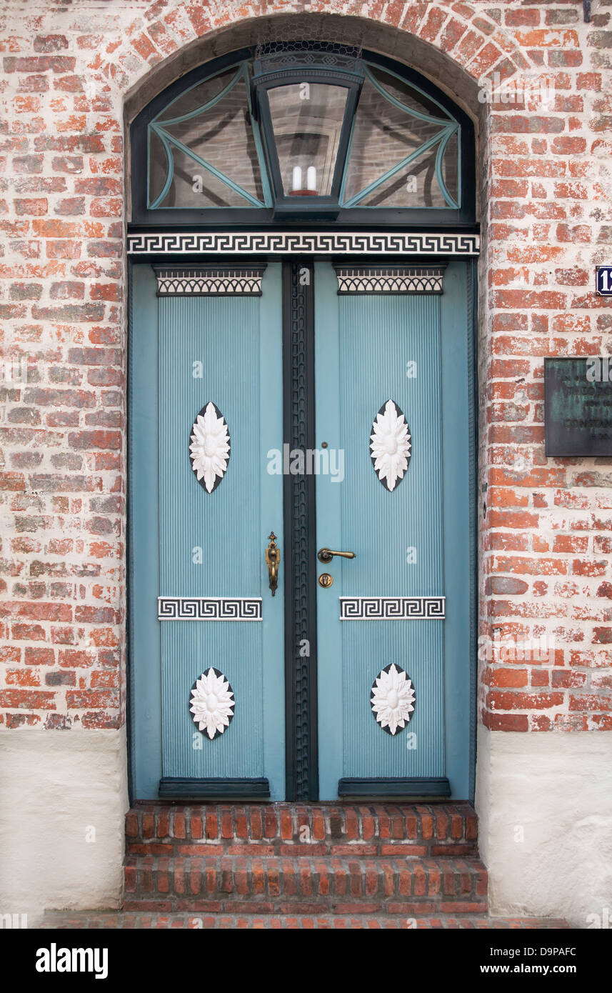 Belle porte en bois bleu avec des ornements encadré dans une redbricked wall Banque D'Images