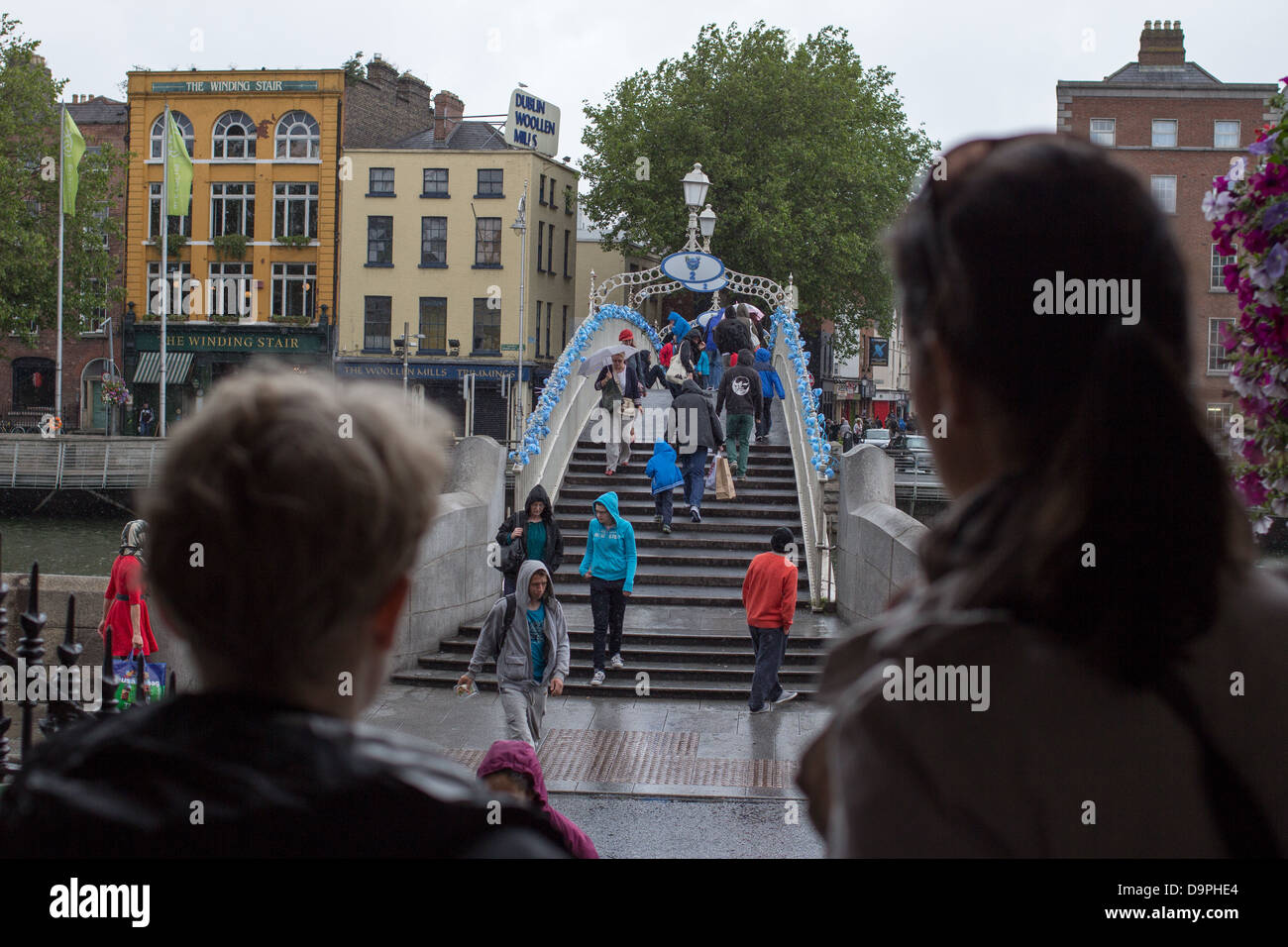 Les gens à pied à travers le Ha'penny Bridge, Dublin, Irlande. Le pont a été décoré pour la Journée mondiale de Schtroumpfs. Banque D'Images