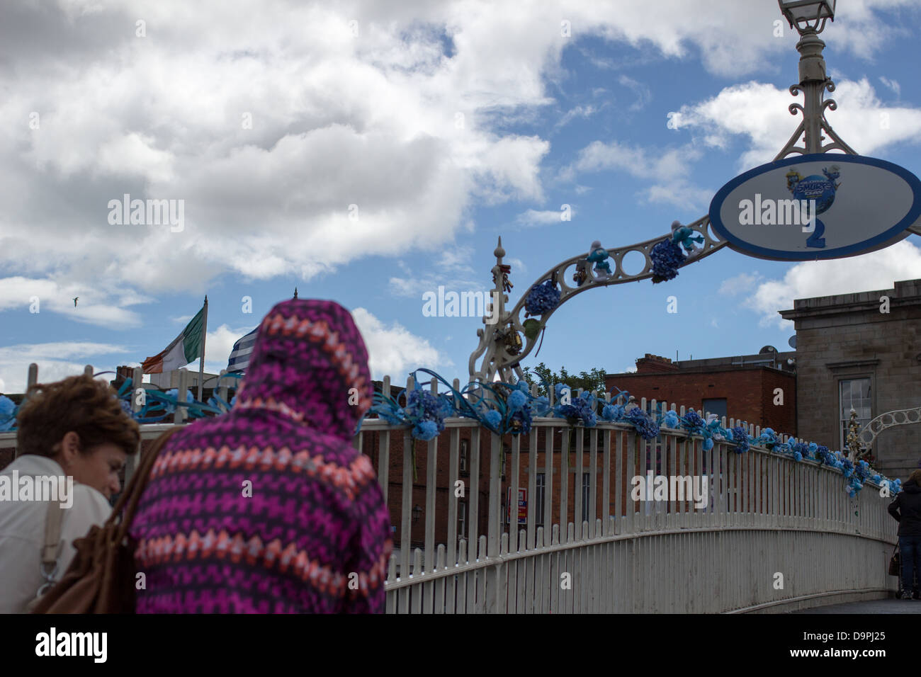 Les gens à pied à travers le Ha'penny Bridge, Dublin, Irlande. Le pont a été décoré pour la Journée mondiale de Schtroumpfs. Banque D'Images