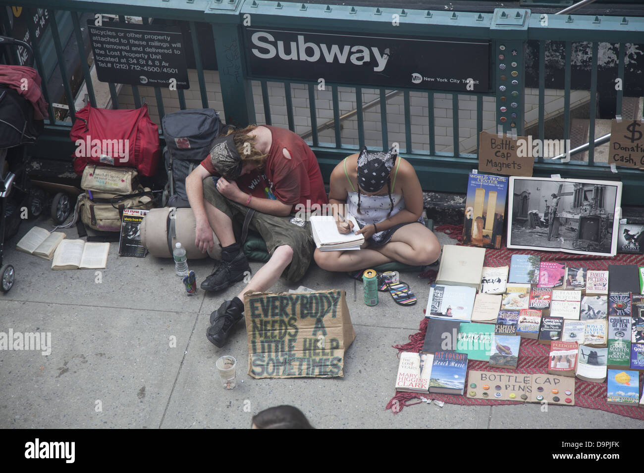 Jeune couple d'essayer de recueillir de l'argent comme les passants shuffle le long sur la 14e Rue à Union Square, NEW YORK Banque D'Images
