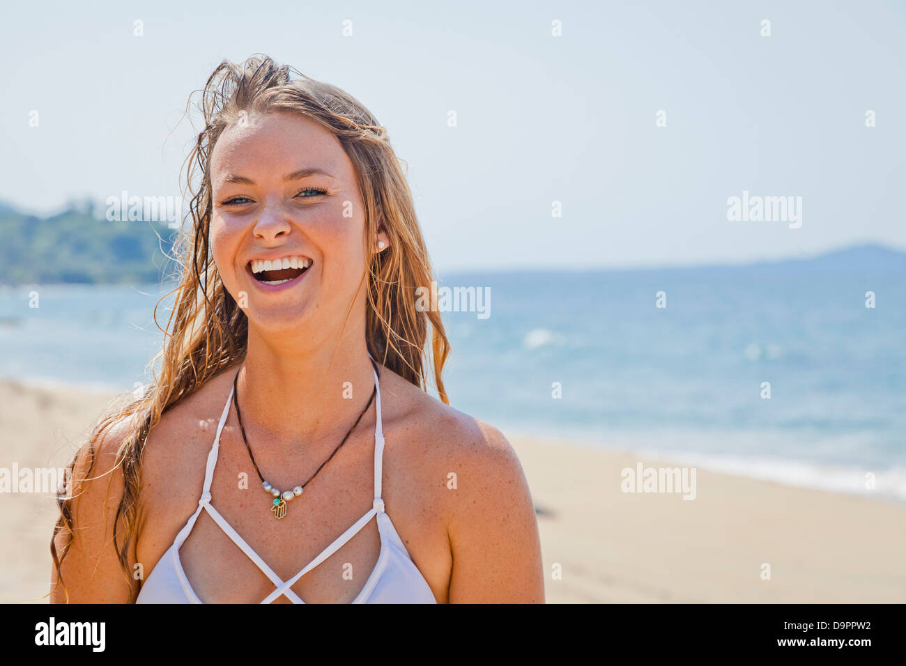 Portrait of young laughing woman on beach Banque D'Images