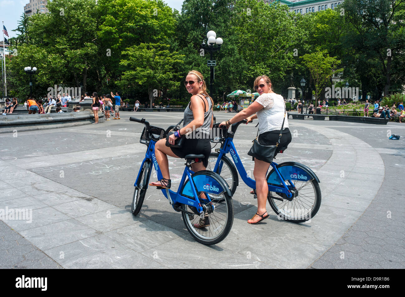 La ville de New York, NY - les femmes touristes circonscription CitiBikes à Washington Square Park Banque D'Images