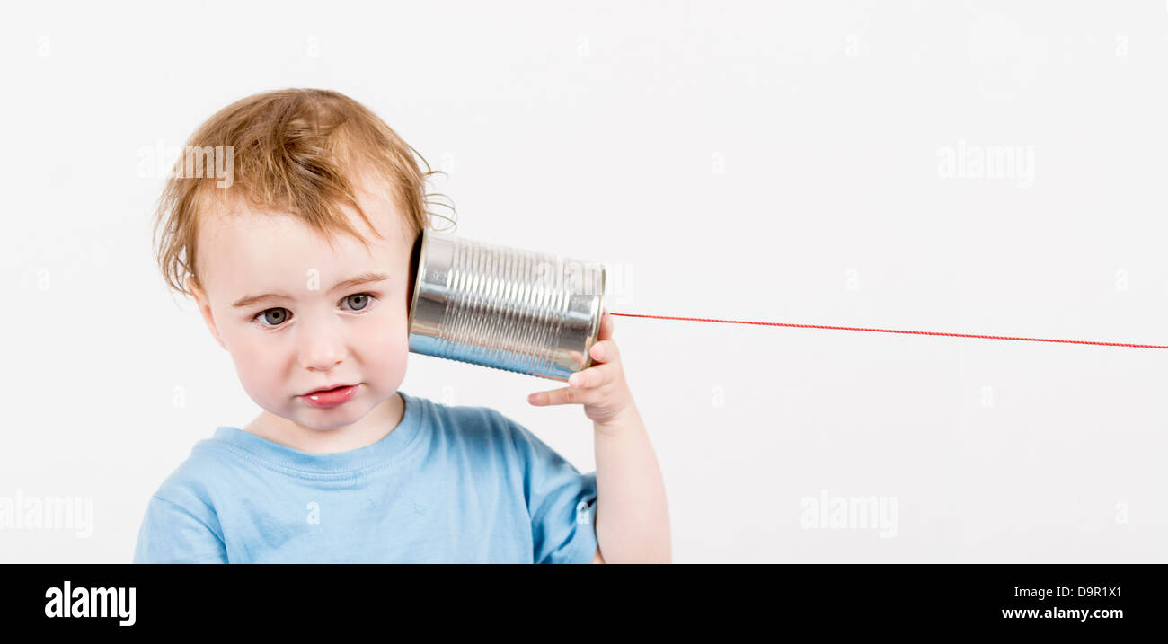 Les jeunes, l'écoute de l'enfant déçu tin can téléphone. caucasien enfant en image horizontale Banque D'Images