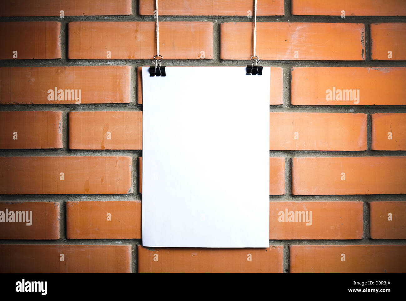 Blank white poster sur une corde, mur de brique sur l'arrière-plan Banque D'Images