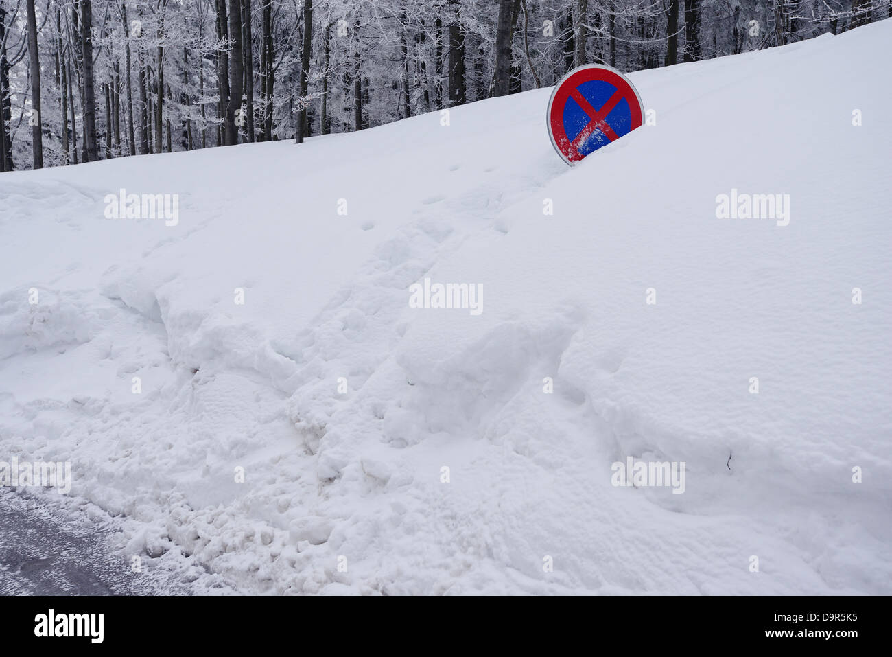Un panneau routier presque couvert dans un banc de neige, Banque D'Images