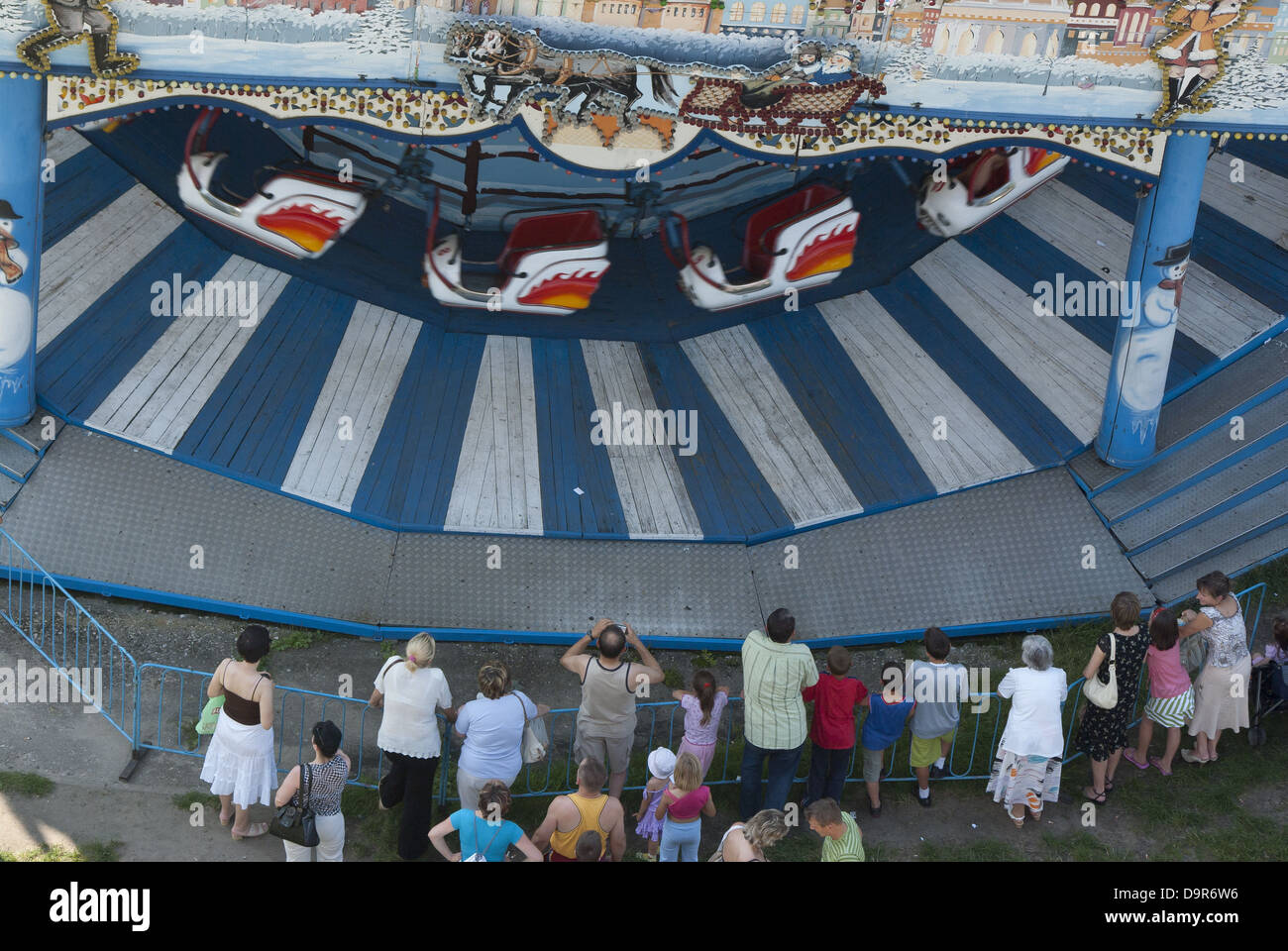 Un groupe de personnes regardant le manège en bois du parc d'attractions à Lodz, Pologne Banque D'Images