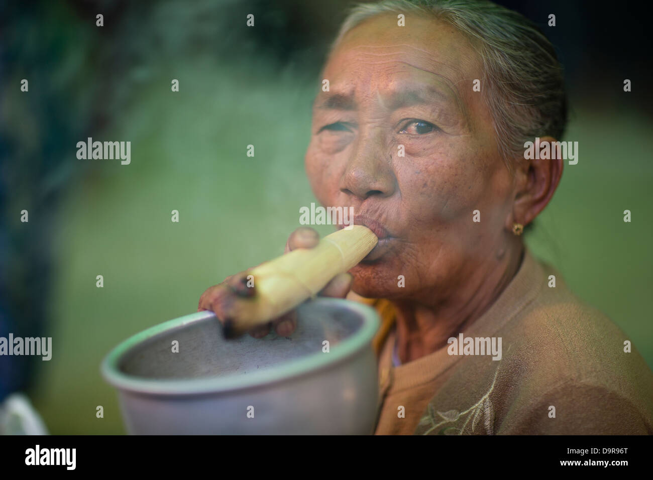Une femme qui fume à la Shwezigon Paya, Bagan, Myanmar (Birmanie) Banque D'Images