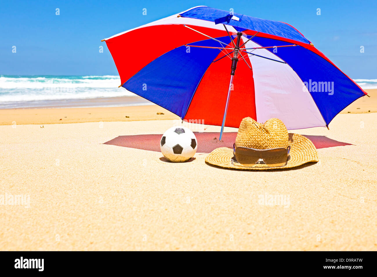 Chapeau de paille, lunettes de soleil et un parasol sur la plage Photo  Stock - Alamy