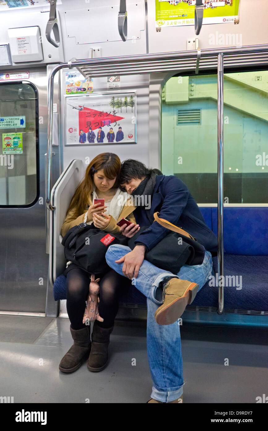 Jeune couple sur le métro de Tokyo Banque D'Images