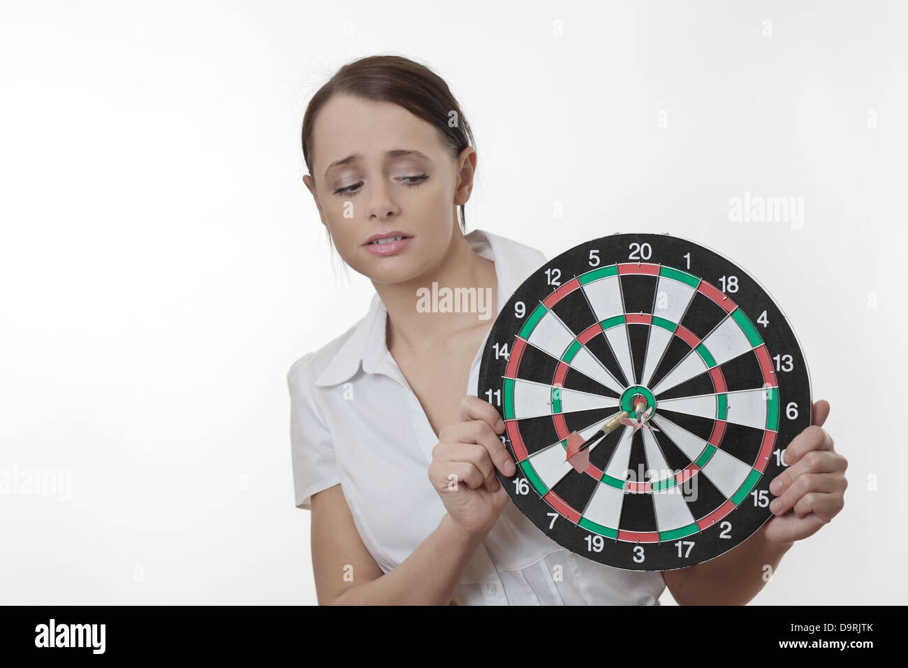 Businesswoman looking sur un jeu de fléchettes comme si elle est sur le point d'être tourné Banque D'Images Businesswoman looking sur un jeu de fléchettes comme si elle est sur le point d'être tourné Banque D'Images