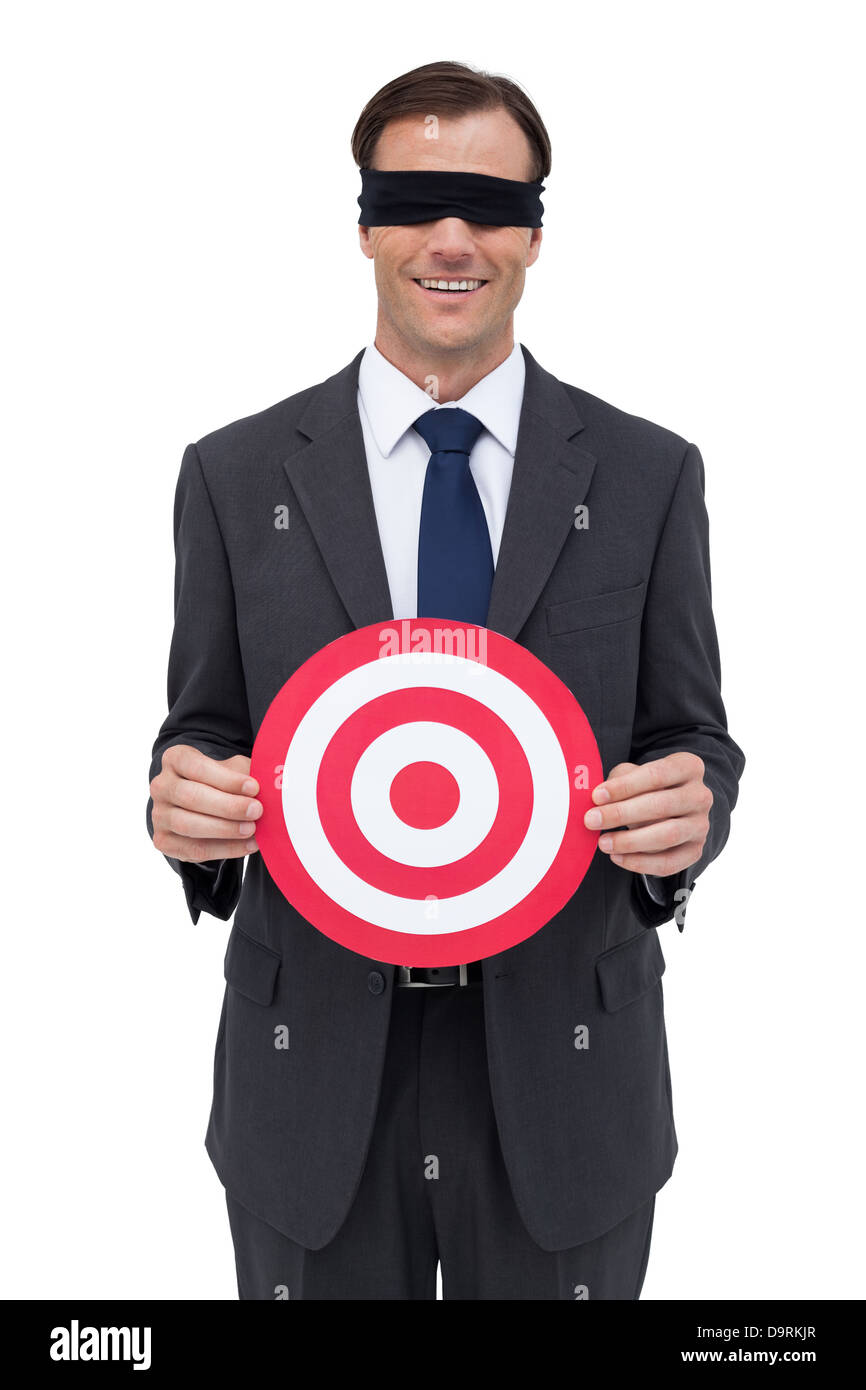 Les yeux bandés et smiling businessman holding une cible rouge Banque D'Images