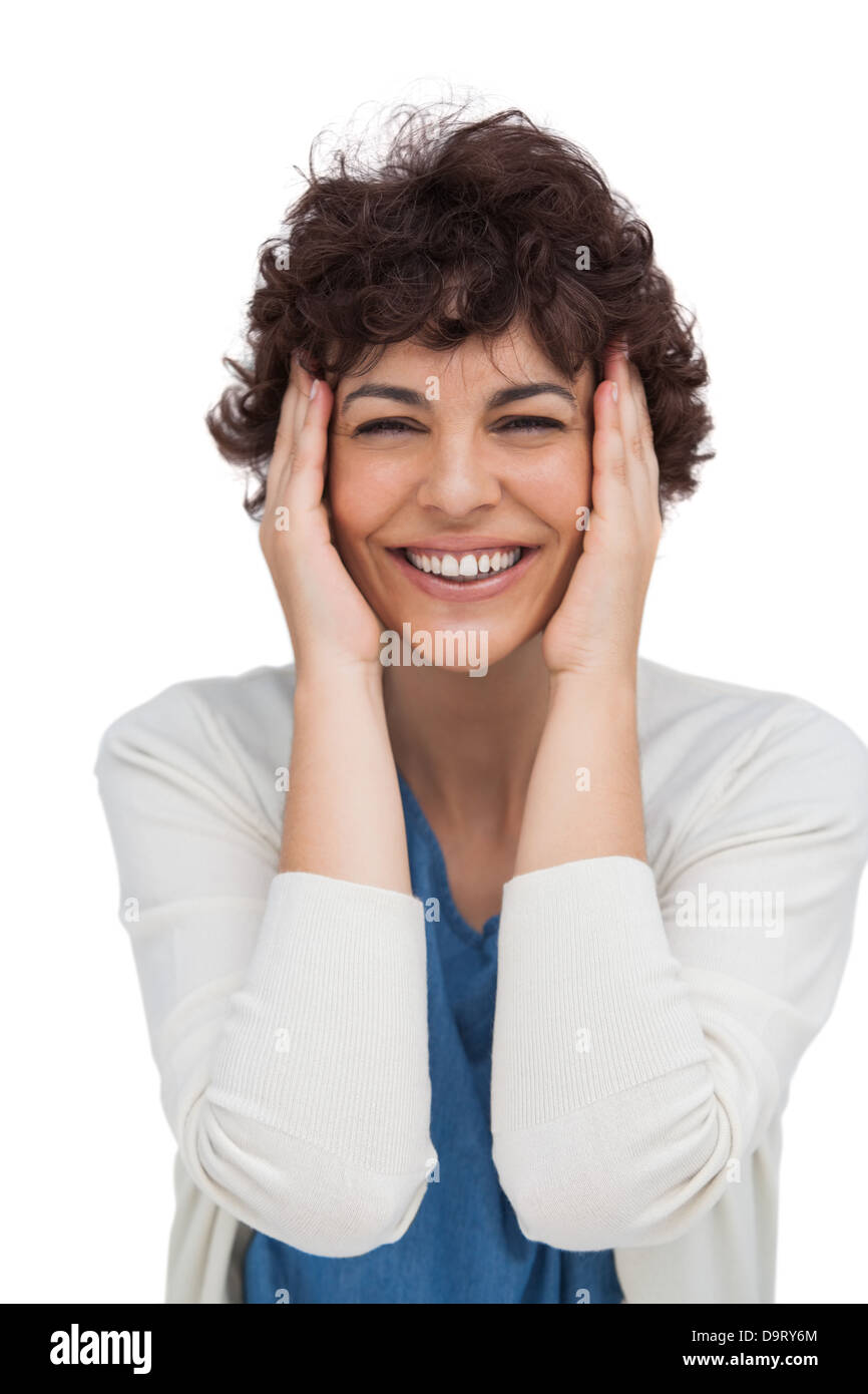 Cheerful brunette woman holding sa tête entre les mains Banque D'Images