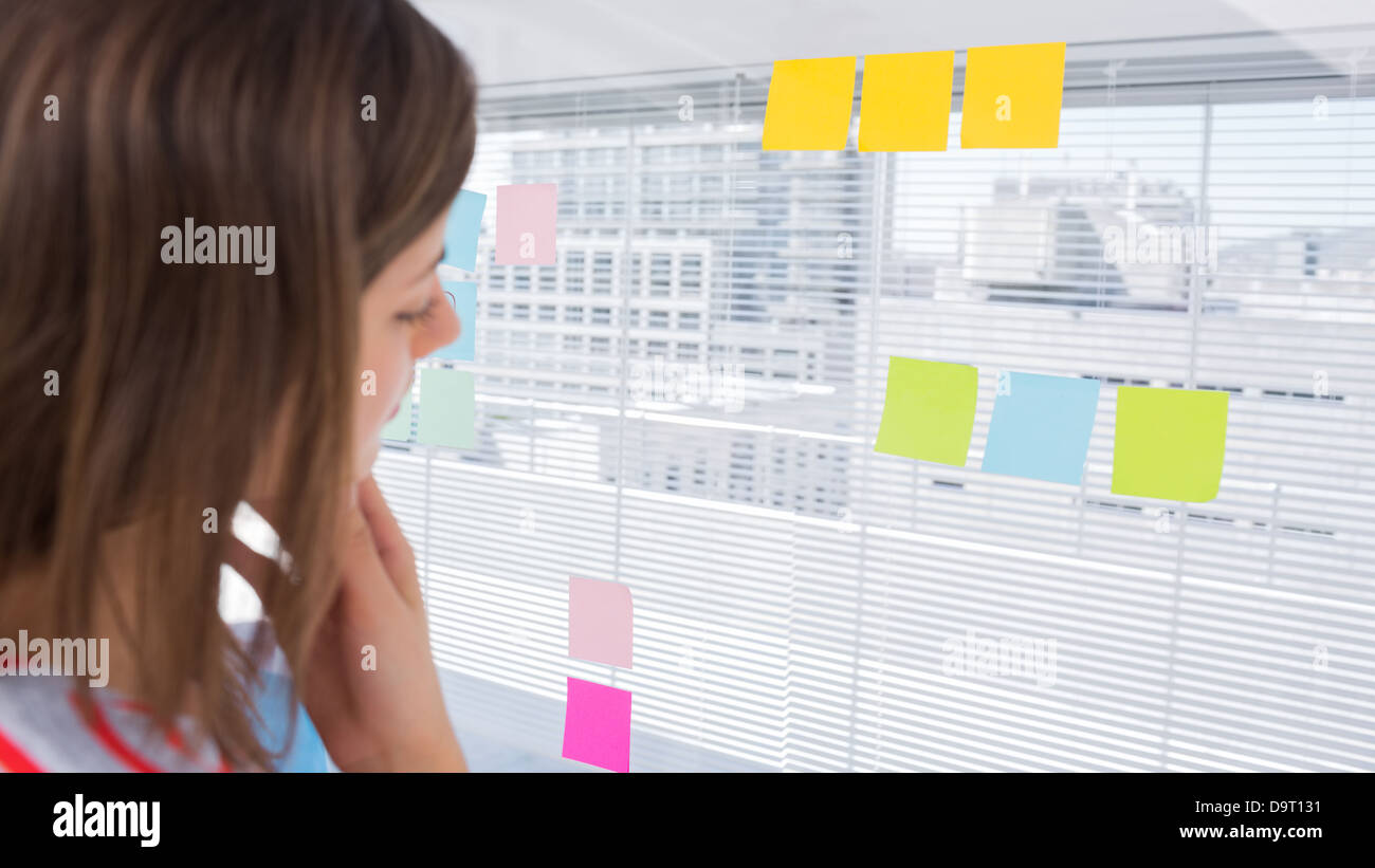 Woman looking at sticky note Banque D'Images