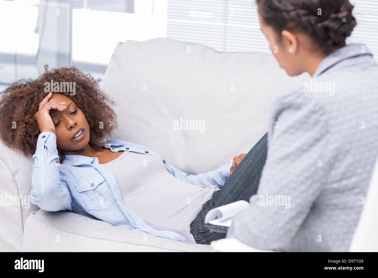 Femme sur canapé en lui disant problèmes Banque D'Images