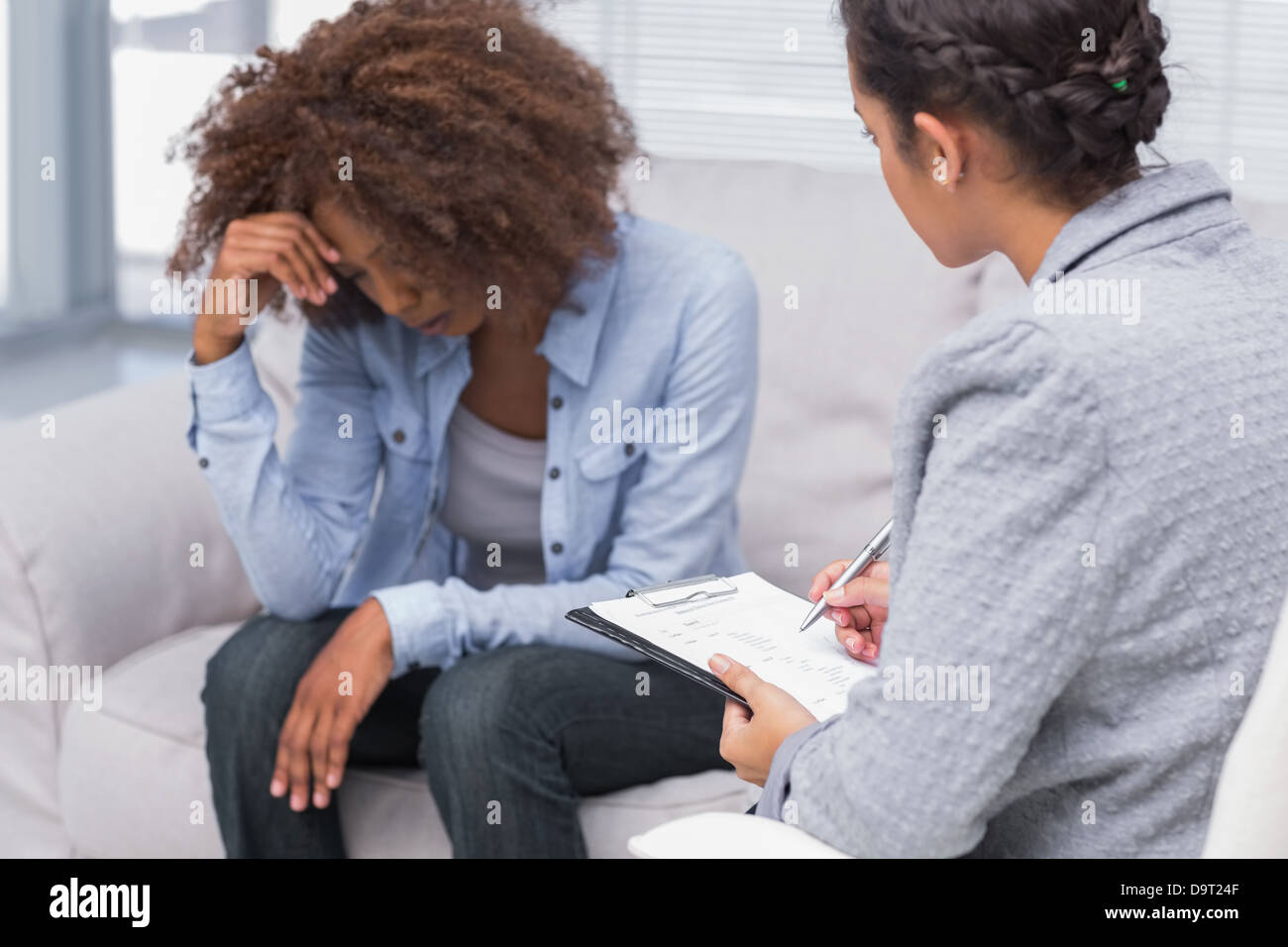 Femme assise sur la table en regardant les thérapeutes Banque D'Images