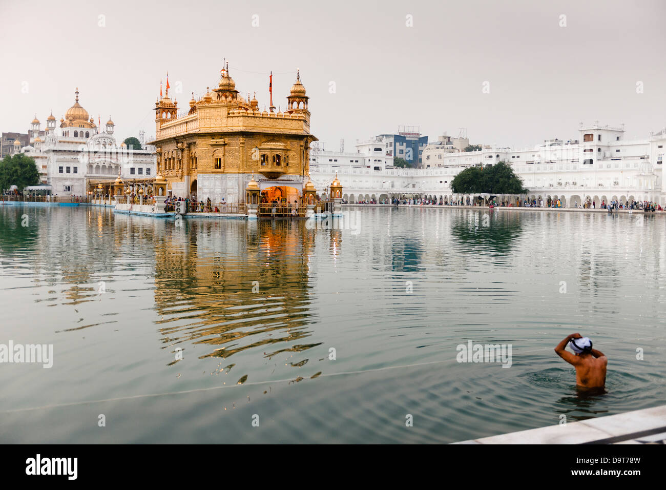 Baignade dans la piscine du Nectar de l'Immortalité au Golden Temple à Amritsar, en Inde. Banque D'Images