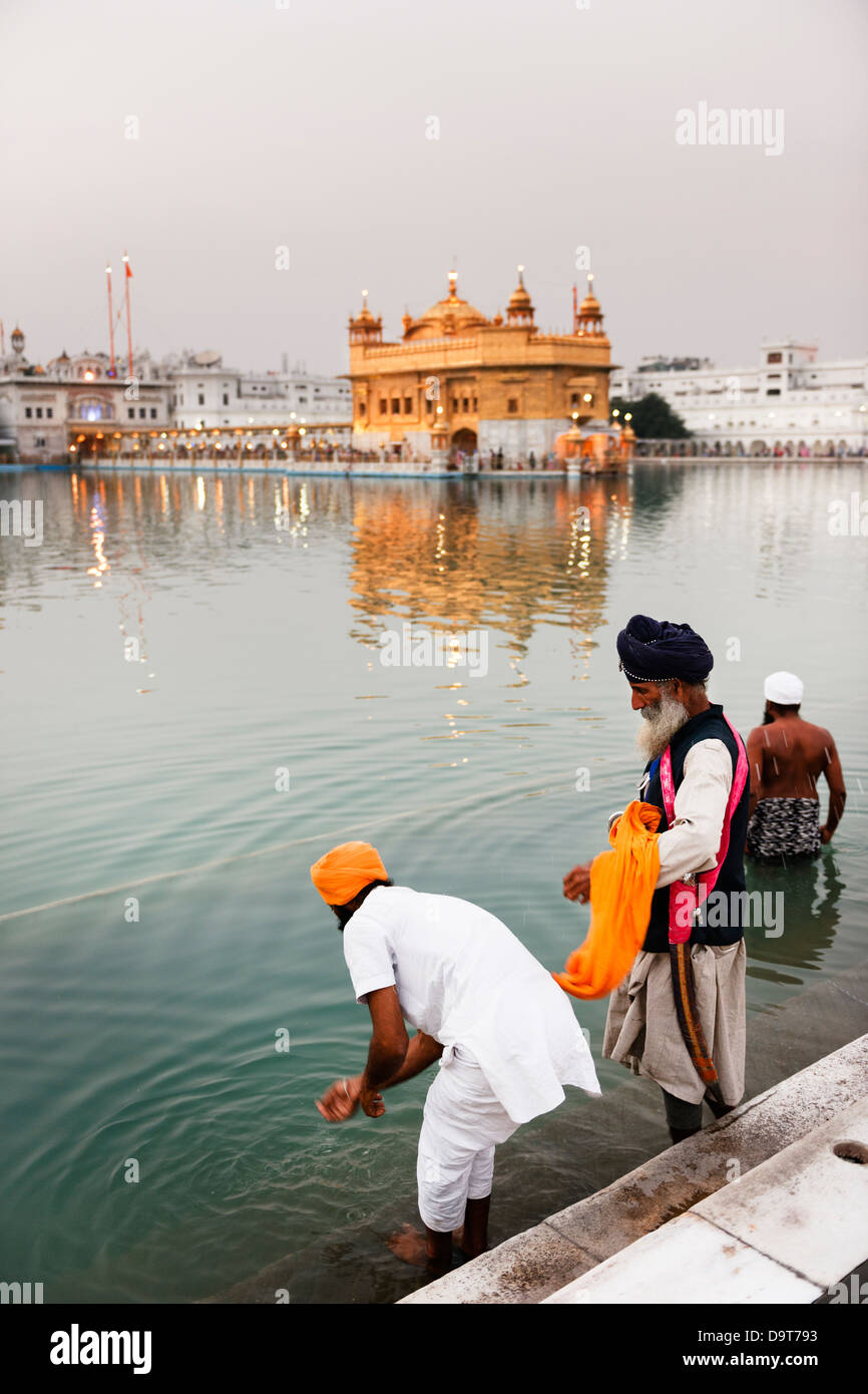 Baignade dans la piscine du Nectar de l'Immortalité au Golden Temple à Amritsar, en Inde. Banque D'Images