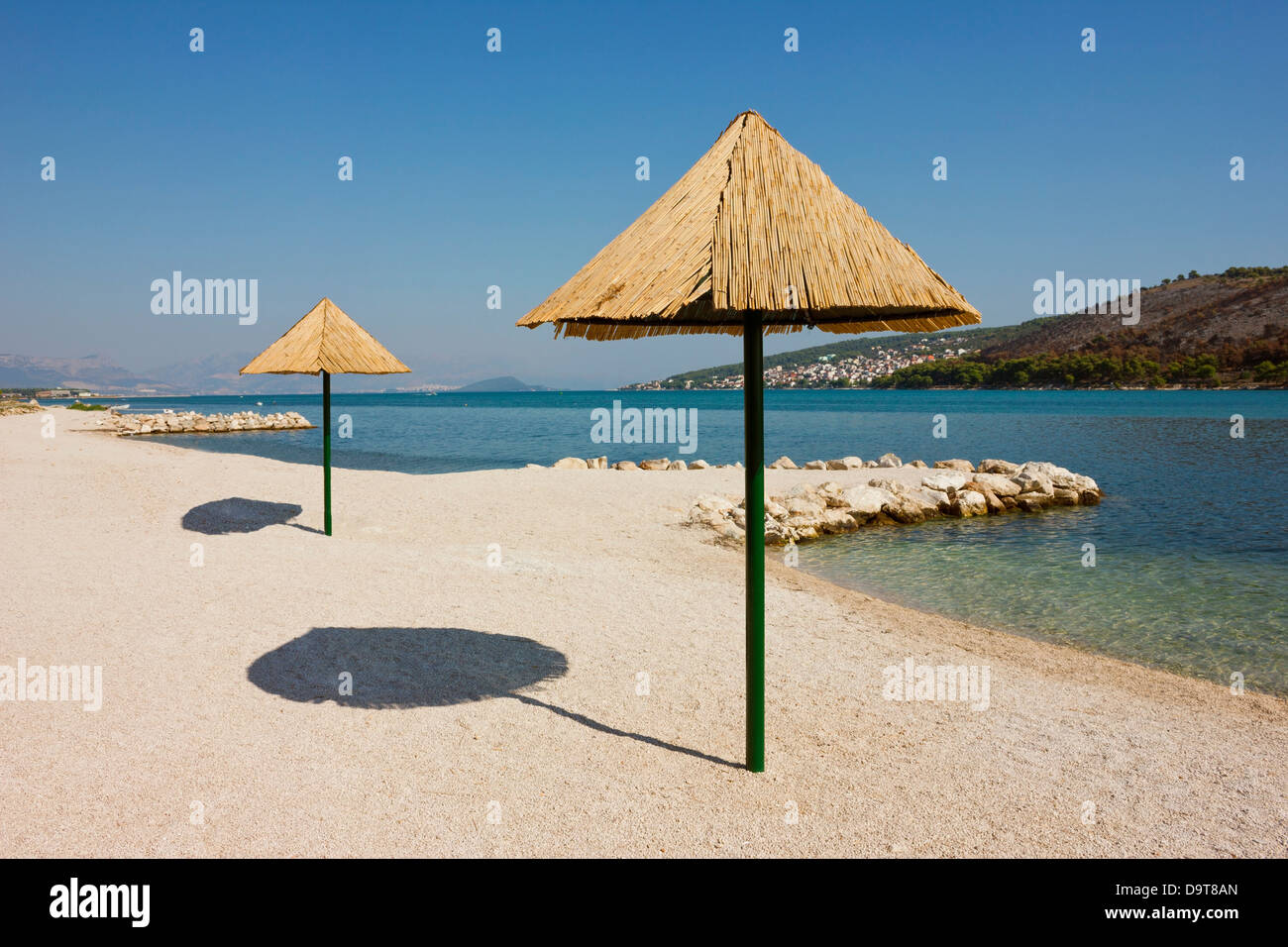 Belle plage à distance sur le littoral adriatique près de Trogir en Croatie avec crystal clear invitant au calme de l'eau. Banque D'Images