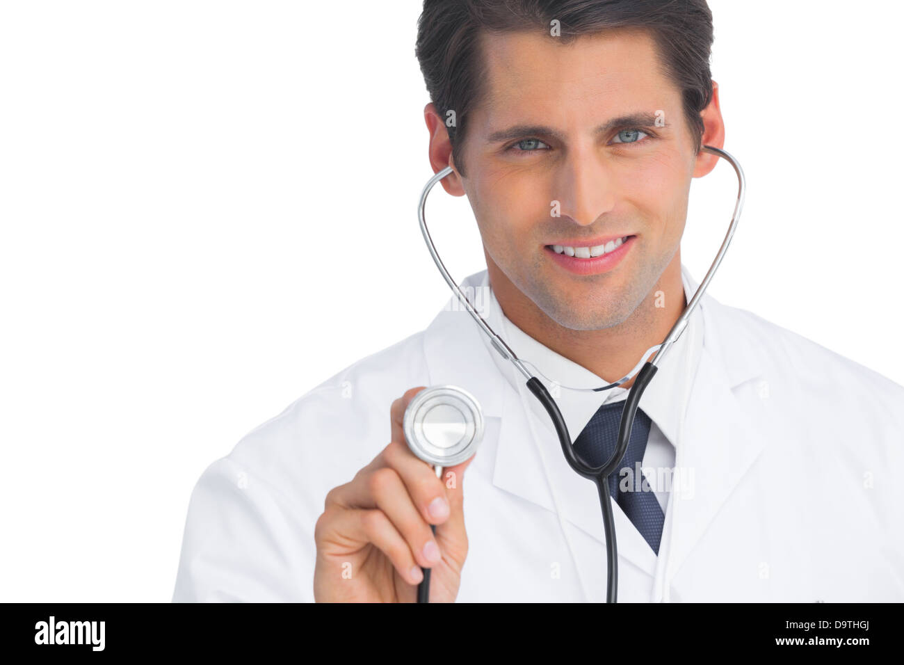 Doctor smiling and holding up stethoscope Banque D'Images