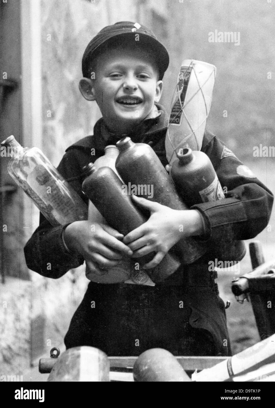 Un garçon, portant l'uniforme de la Jeunesse allemande, a recueilli des bouteilles vides et les porte au point de collecte des bouteilles. Date et lieu inconnus. Fotoarchiv für Zeitgeschichte Banque D'Images
