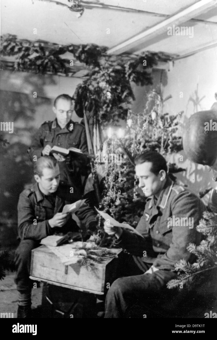 Les soldats de la Wehrmacht allemande ont lu des lettres dans un bunker sur le front est le Noël 1944. La propagande nazie! Au dos de l'image est la date 18 décembre 1944: 'Noël de guerre 1944! Les volontaires de guerre de la Tank Grenadier Division « Grande Allemagne » le soir de Noël. Le poste sur le terrain a livré le courrier de Noël à temps.' Fotoarchiv für Zeitgeschichte Banque D'Images