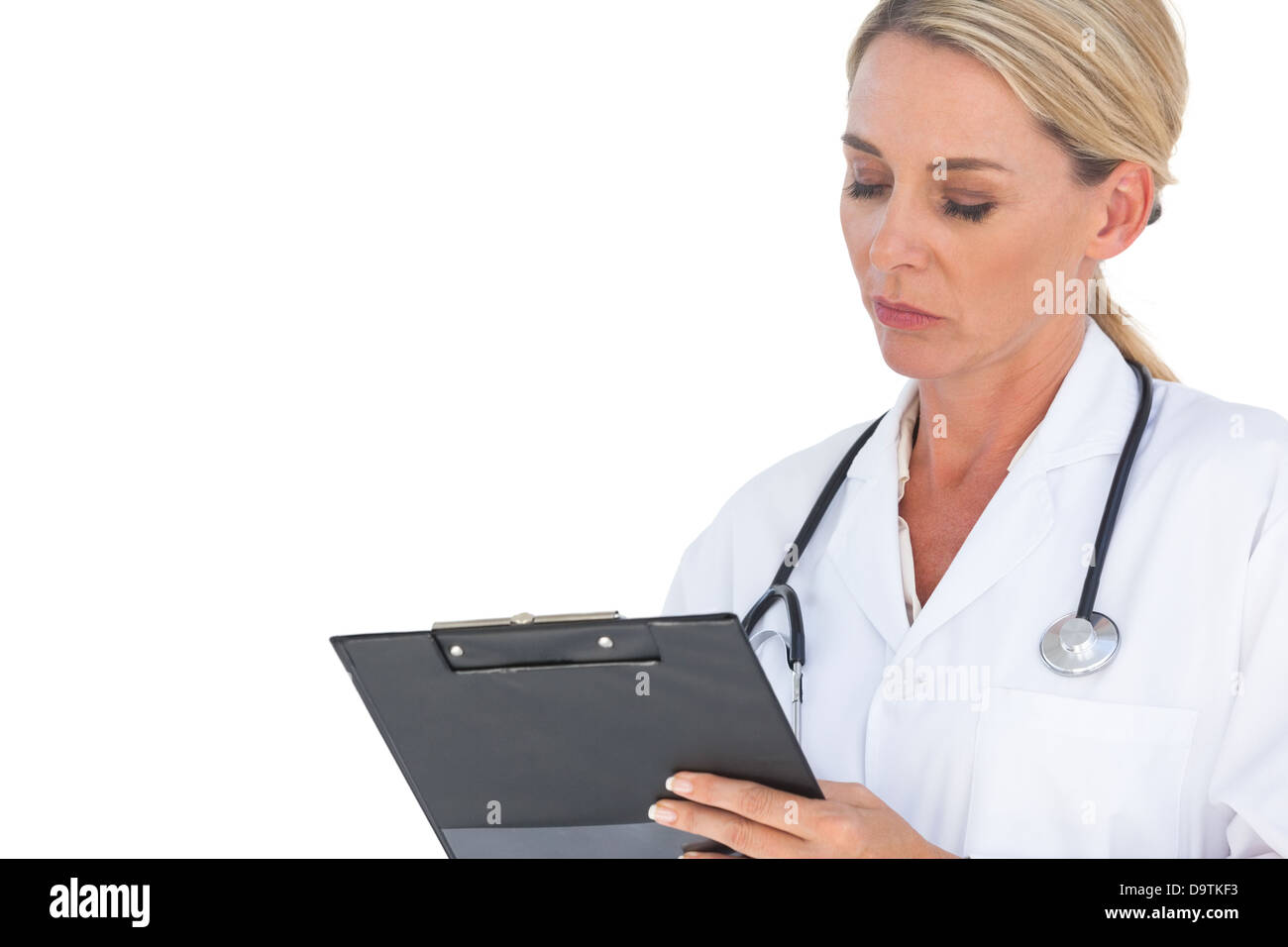 Médecin avec stéthoscope autour de son cou writing on clipboard Banque D'Images