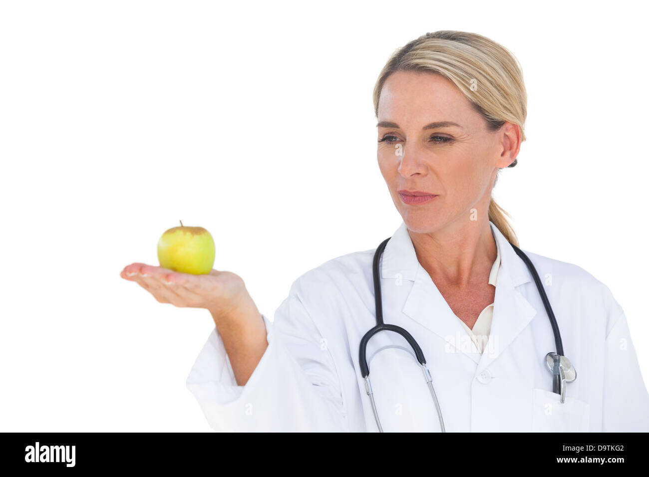 Smiling doctor holding apple et à le regarder Banque D'Images