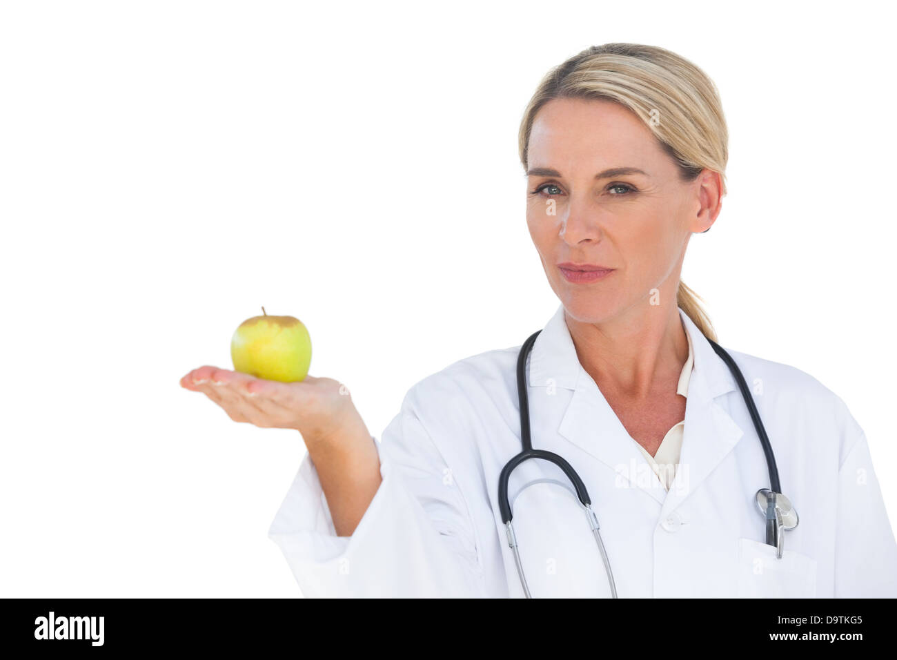 Smiling doctor holding apple and looking at camera Banque D'Images