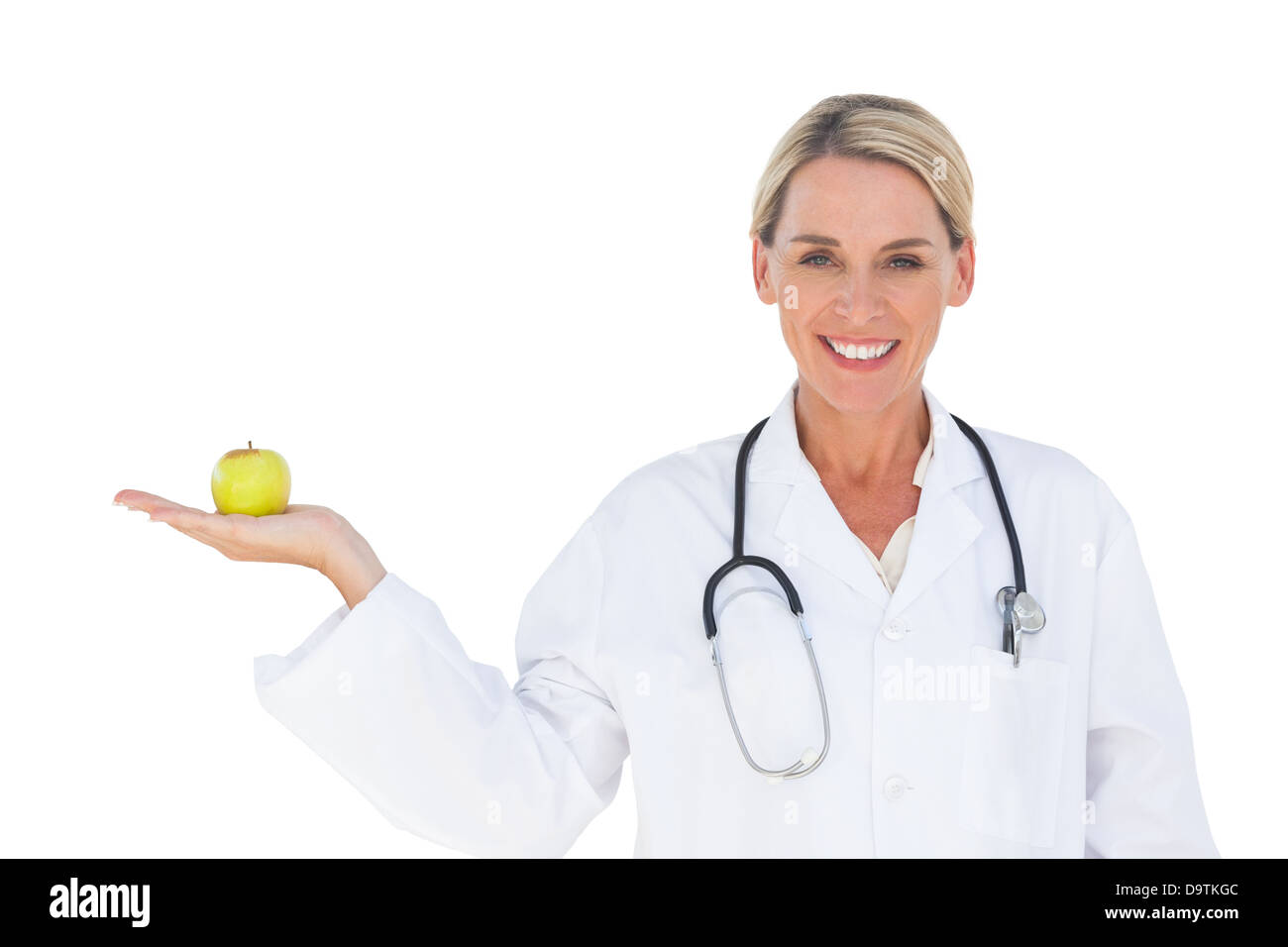 Happy doctor holding apple et looking at camera Banque D'Images