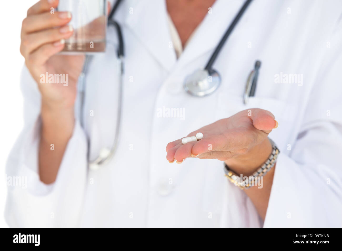 Doctor holding out tablets et verre de l'eau Banque D'Images