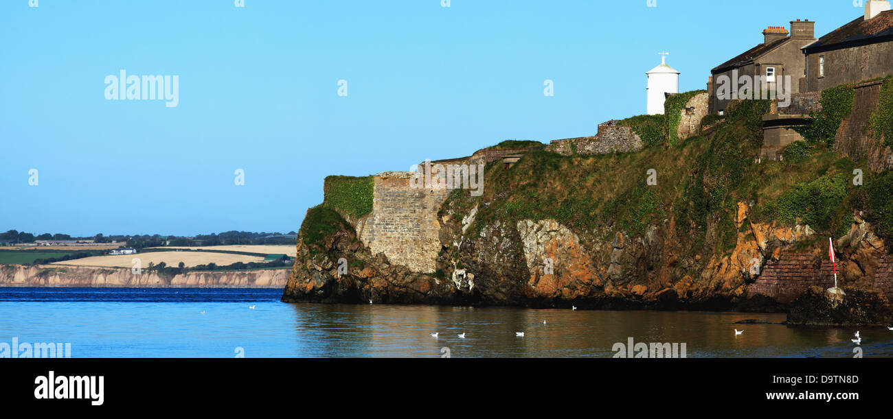 Un mur le long de la côte avec des maisons jusqu'au-dessus et bleu ciel;le comté de Wexford Irlande Duncannon Banque D'Images