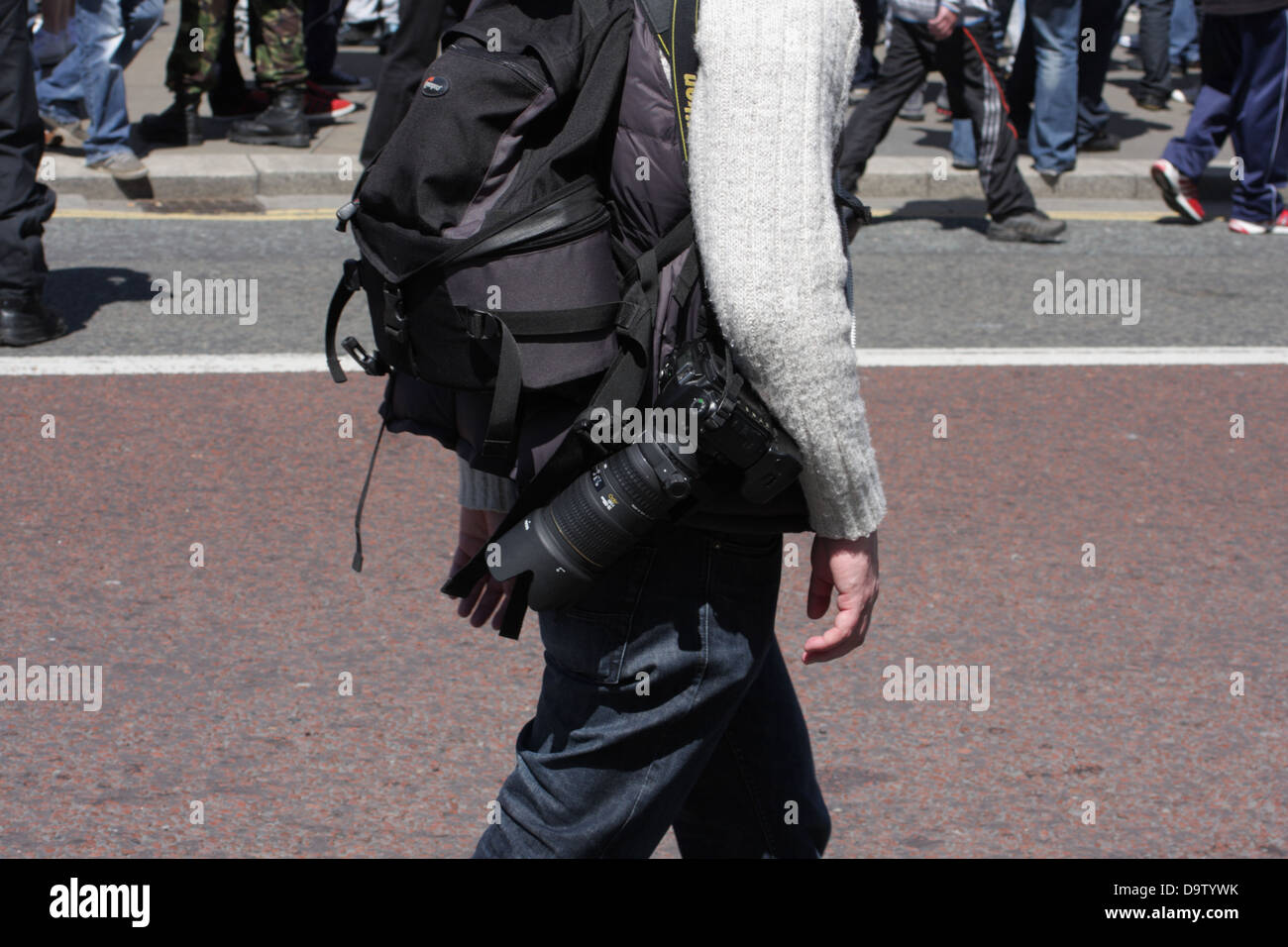 Un photographe, l'homme avec l'appareil photo de l'équipement, en passant devant une foule lors d'une manifestation de l'EDL à Newcastle upon Tyne. Banque D'Images