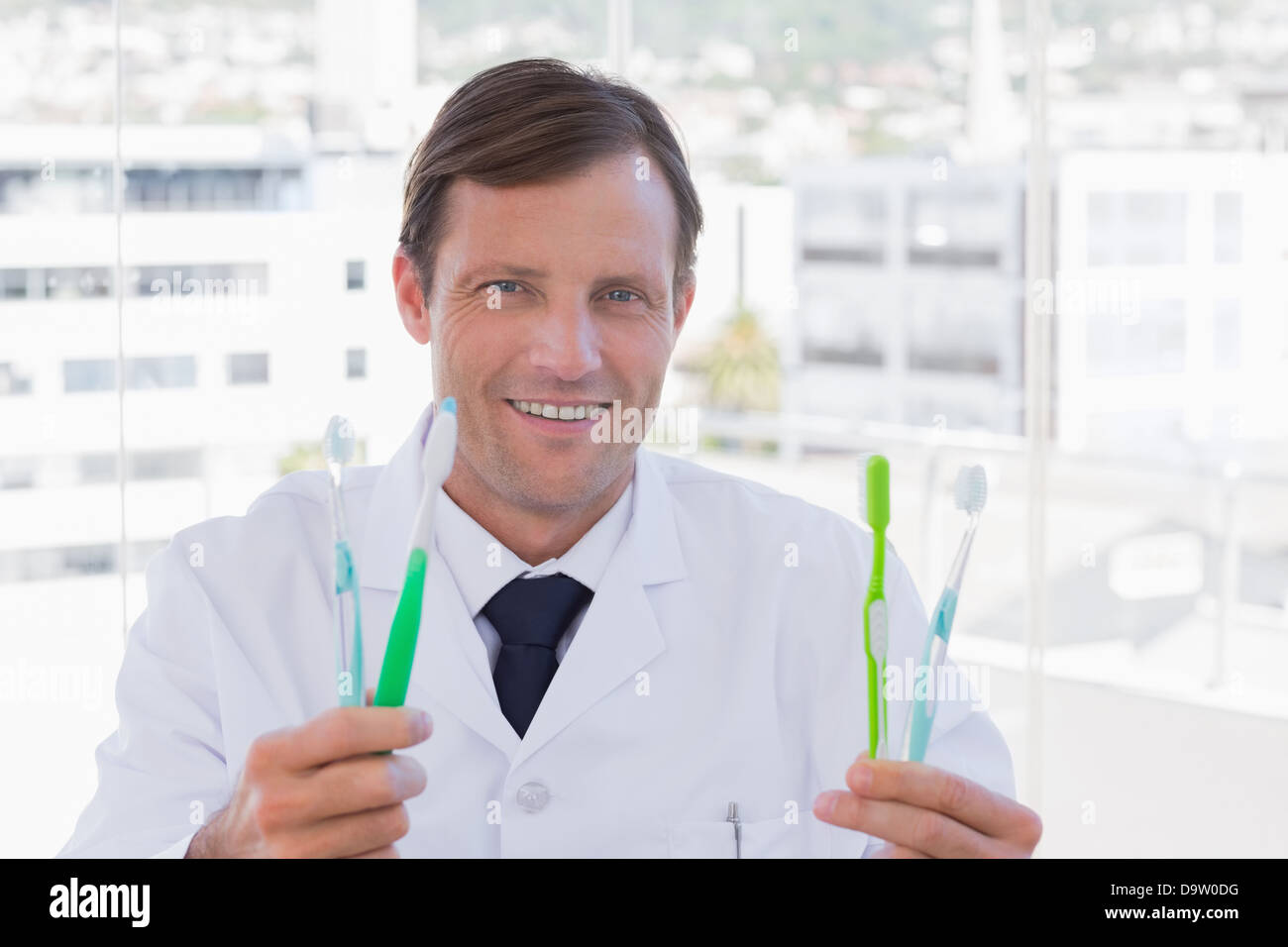 Happy doctor holding deux brosses à dents Banque D'Images