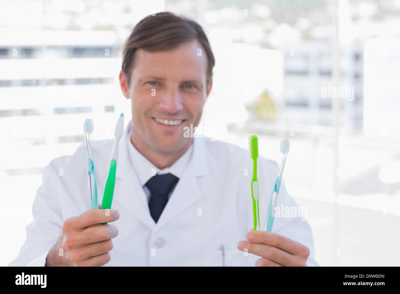 Smiling doctor holding deux brosses à dents Banque D'Images