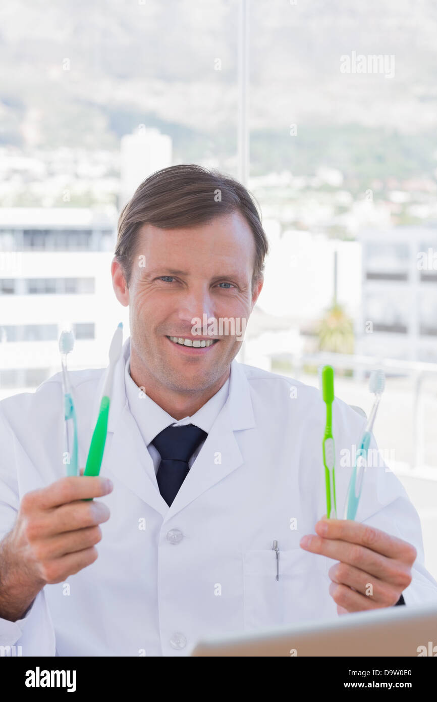 Cheerful doctor holding deux brosses à dents Banque D'Images