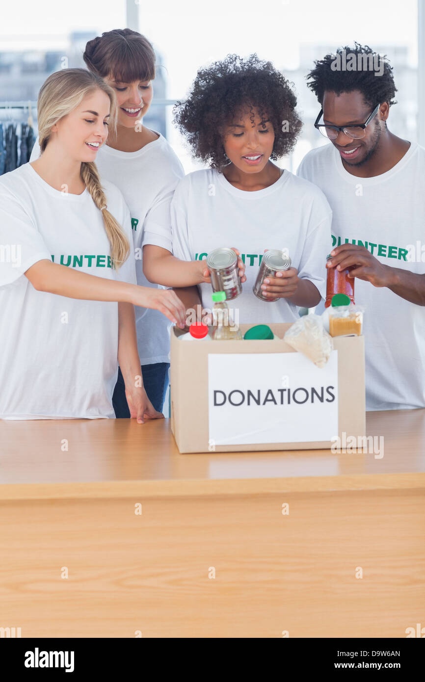 Les bénévoles mettre des aliments en boîte de donation Banque D'Images