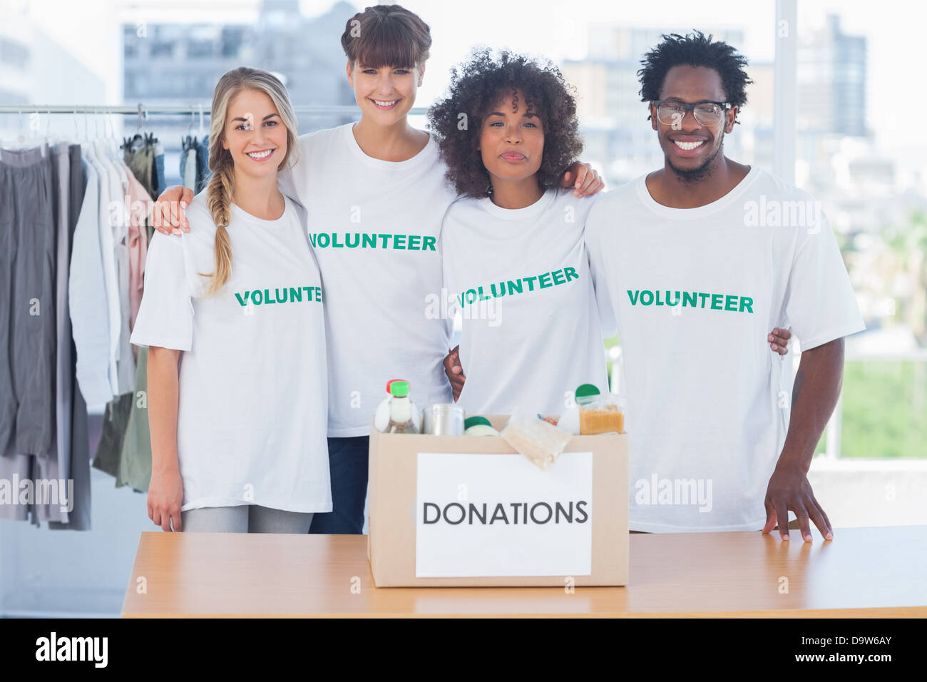 Les bénévoles debout devant de la nourriture dans une boîte de donation Banque D'Images