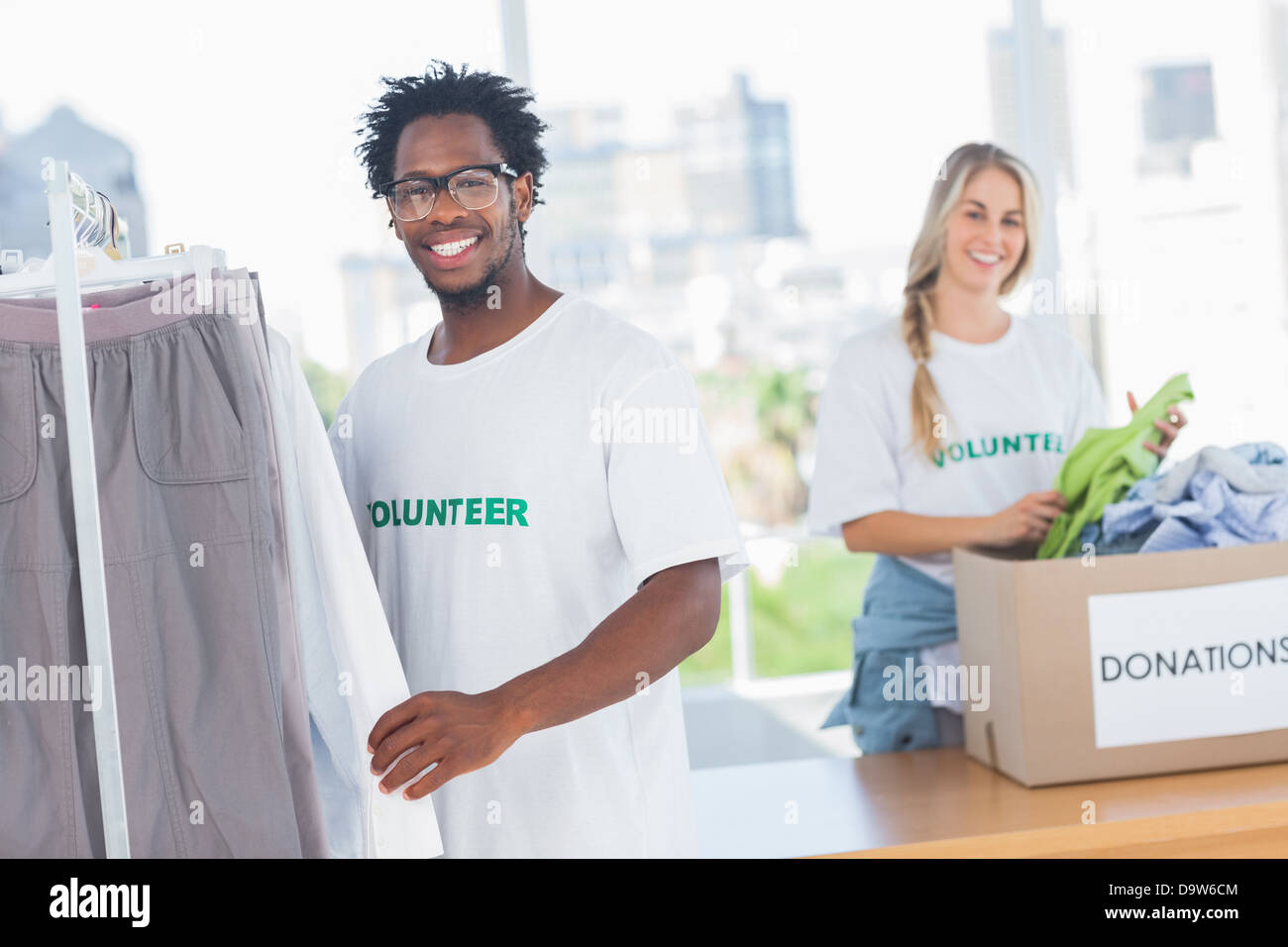 Les bénévoles de prendre assez de vêtements un don fort Banque D'Images