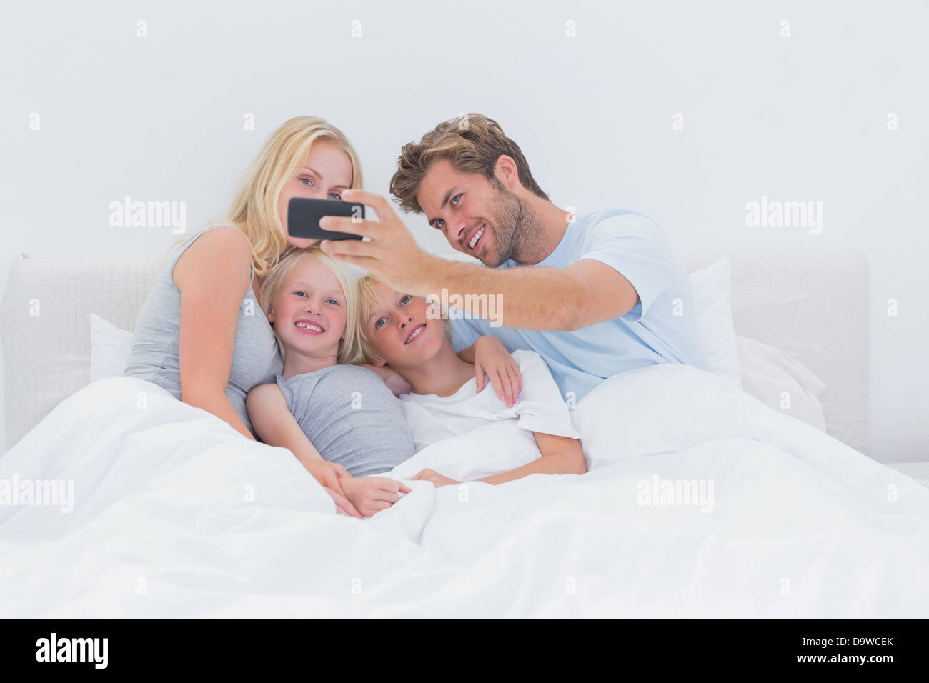 Happy Family taking self photos avec un smartphone Banque D'Images
