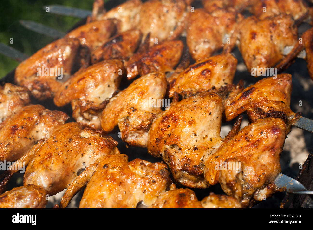 La cuisson de délicieuses ailes de poulet juteux à l'extérieur grill Banque D'Images