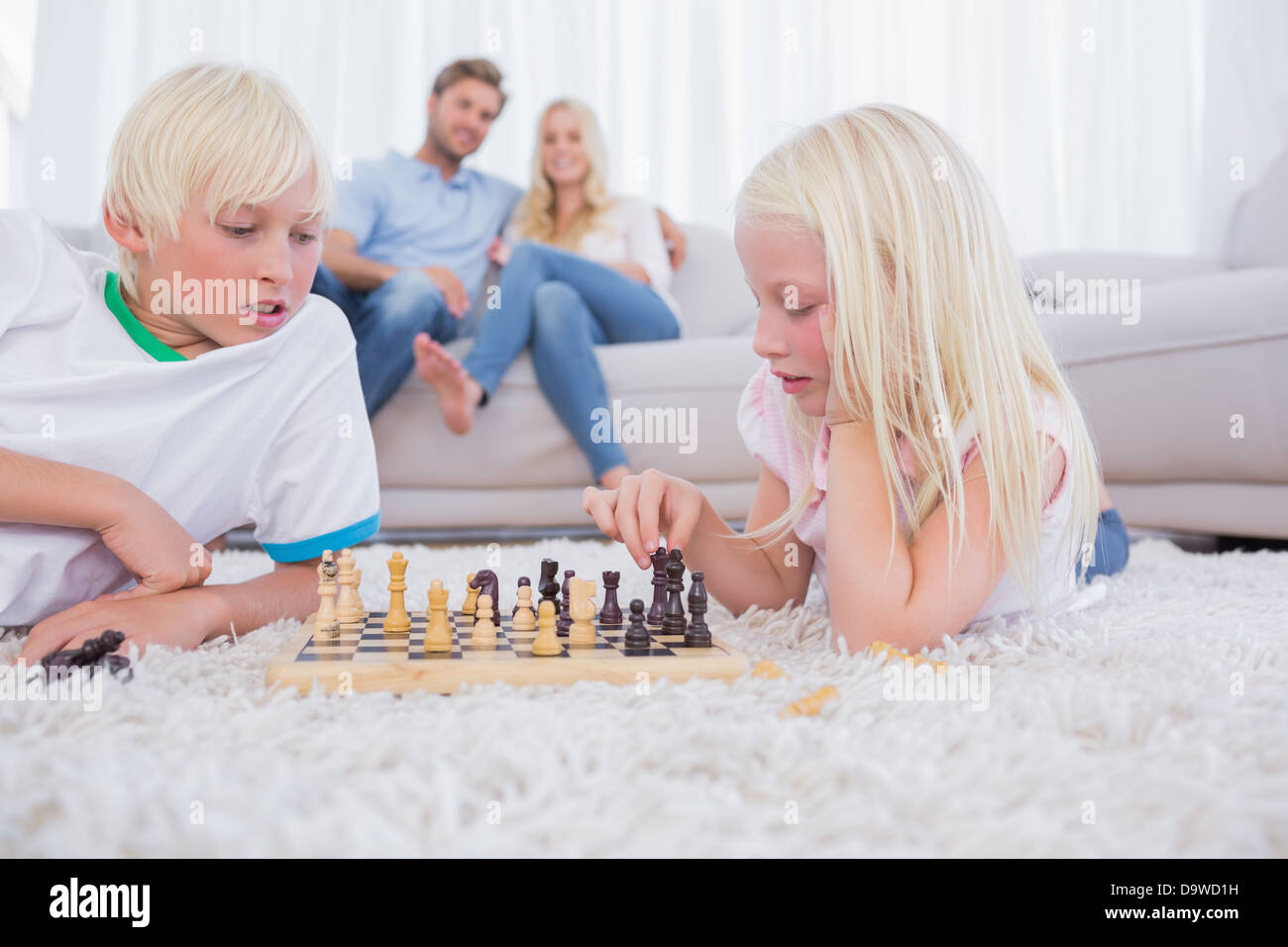 Les parents à leurs enfants à jouer aux échecs Banque D'Images