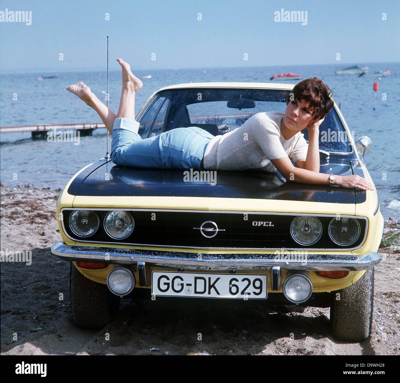 Une jeune femme s'est à l'aise sur le capot moteur de la nouvelle Opel Manta, photographié en 1975. Banque D'Images